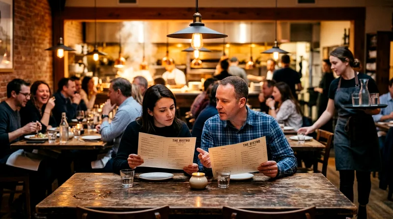 Two diners reviewing menus at a casual restaurant with other guests eating nearby.