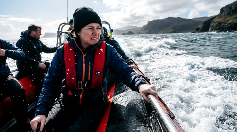 Zodiac passenger gripping rail with uncomfortable expression during choppy conditions.